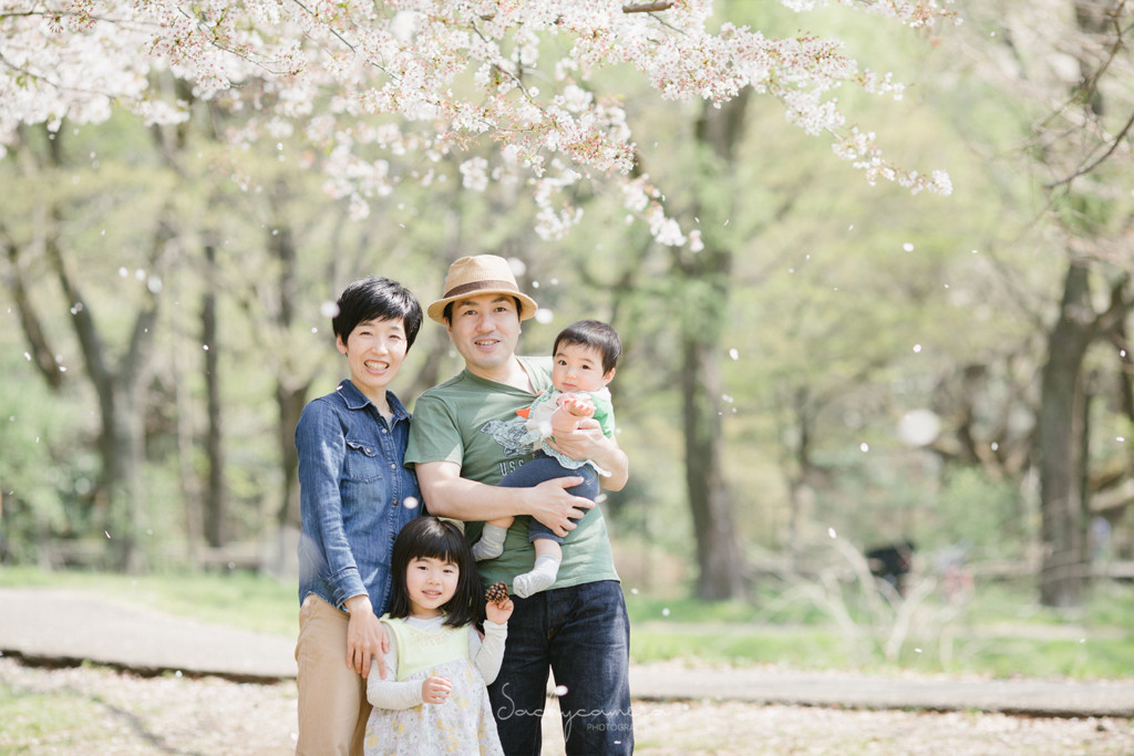 桜吹雪の中の四人家族の集合写真