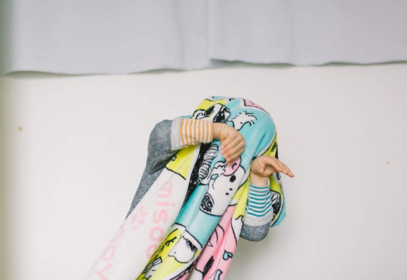 毛布をかぶっておどける子供