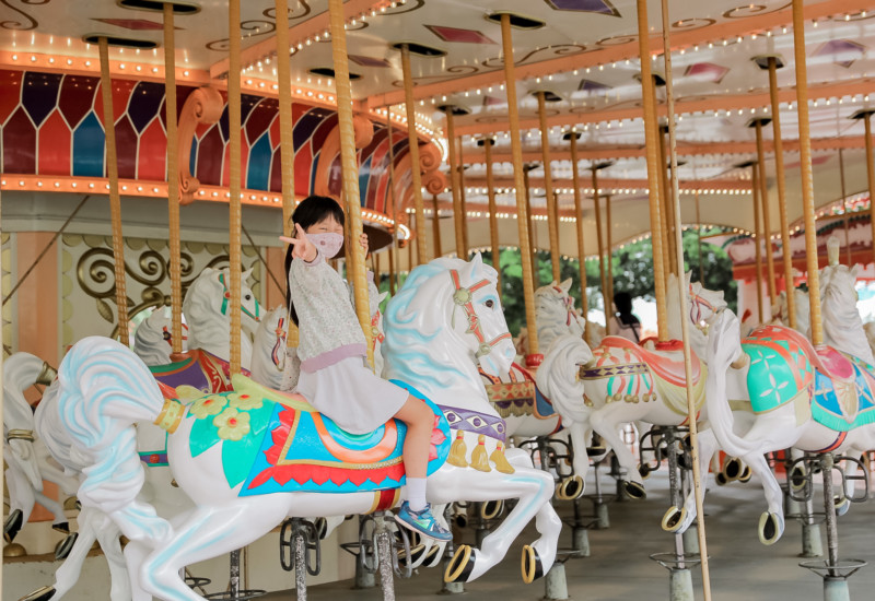 メリーゴーラウンドに乗る娘